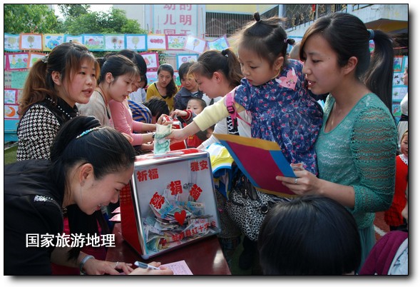 4月27日，婺源縣星星幼兒園的小朋友們?cè)诩议L(zhǎng)的陪同下將愛(ài)心義賣(mài)的錢(qián)進(jìn)行募捐。