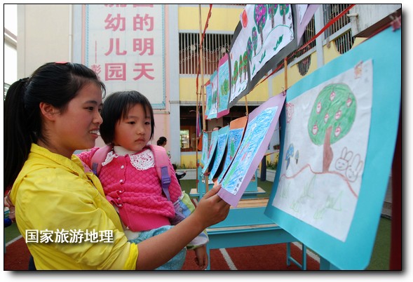 4月27日，婺源縣星星幼兒園的小朋友們?cè)诩议L(zhǎng)的陪同下在挑選愛(ài)心義賣(mài)的作品。